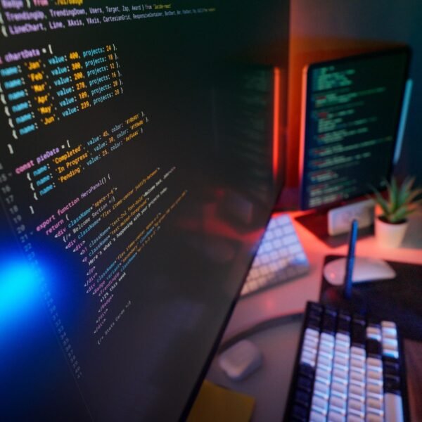 A vibrant workspace featuring colorful code on computer monitors, ideal for developers.