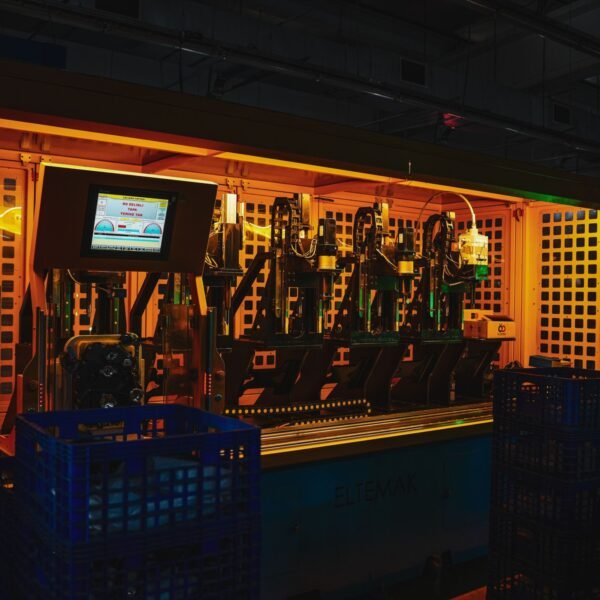 A complex piece of machinery in a dark industrial setting with vibrant lighting.