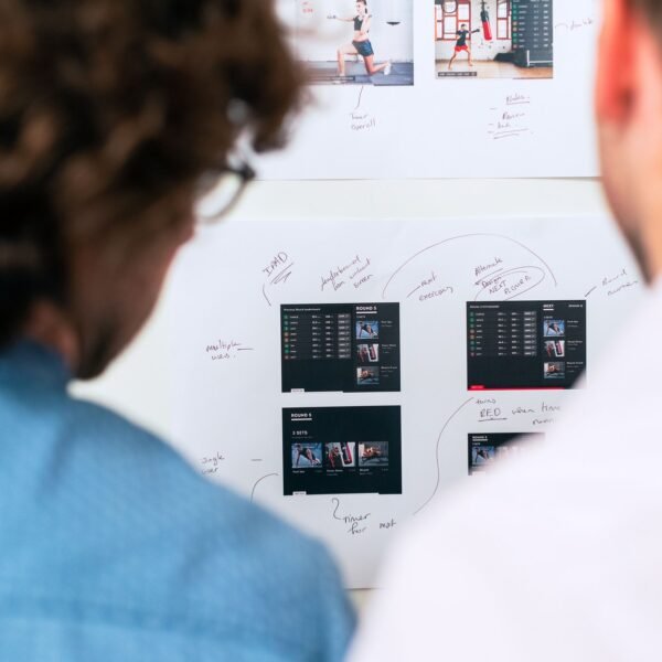 Two business professionals brainstorming and planning software development with a whiteboard in an office.