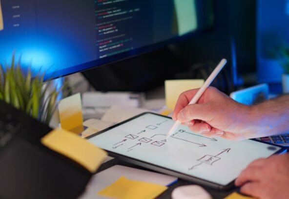 A vibrant workspace featuring digital sketching on a tablet and code on a monitor, showcasing a tech-savvy environment.
