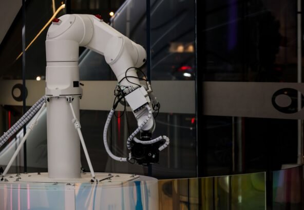 A white robotic arm operating indoors with a modern design and advanced technology.