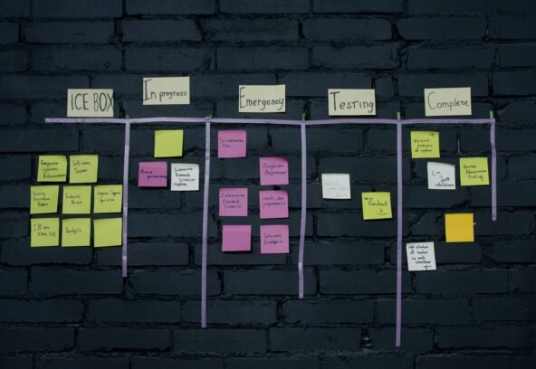 Top-down view of an office Kanban board with colorful sticky notes for task management and organization.