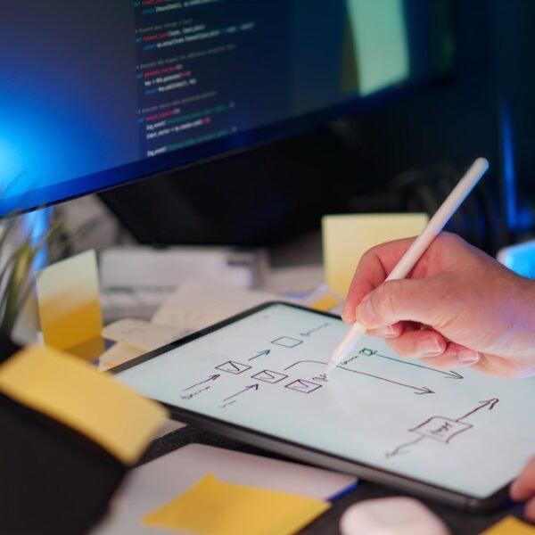 A vibrant workspace featuring digital sketching on a tablet and code on a monitor, showcasing a tech-savvy environment.
